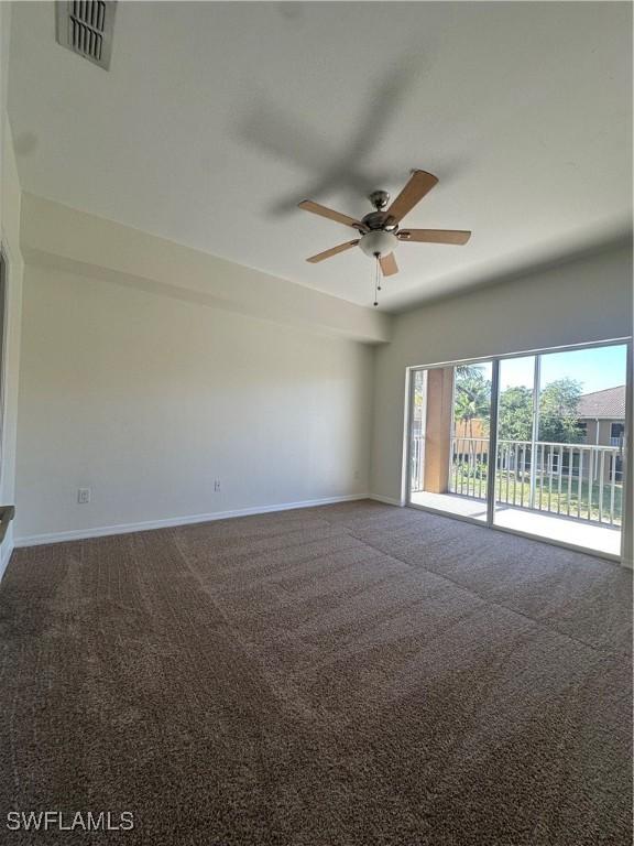 carpeted empty room with baseboards, ceiling fan, and visible vents