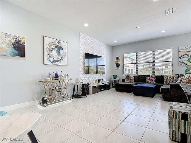living room featuring recessed lighting, visible vents, light tile patterned floors, baseboards, and a textured ceiling