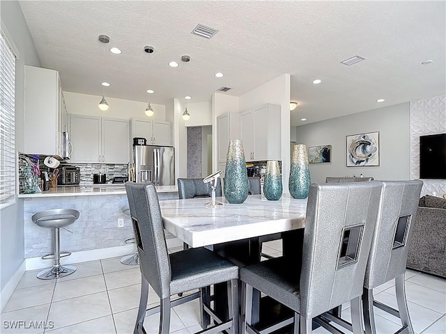 dining room featuring recessed lighting, a textured ceiling, visible vents, and light tile patterned floors