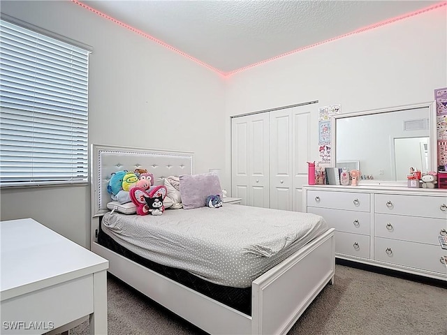 bedroom with carpet flooring, visible vents, and a closet