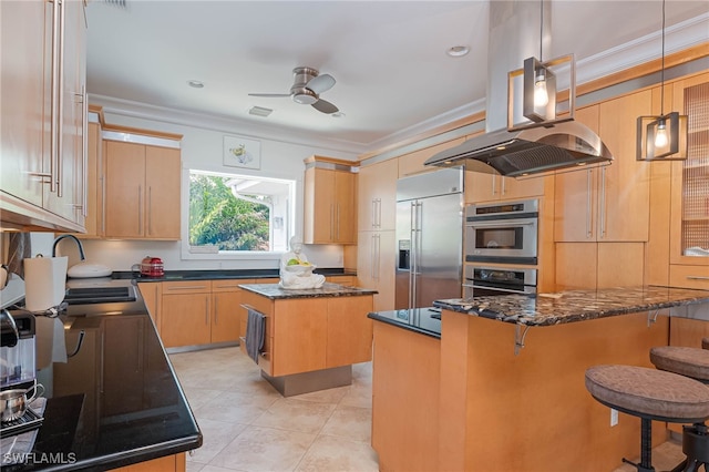 kitchen with a sink, dark stone countertops, ornamental molding, a ceiling fan, and appliances with stainless steel finishes