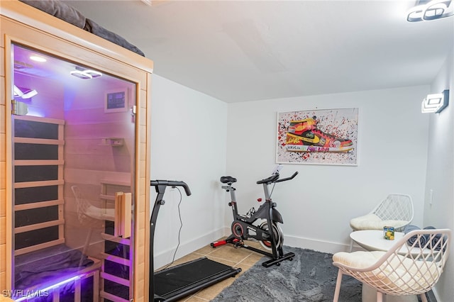 exercise area featuring tile patterned flooring and baseboards