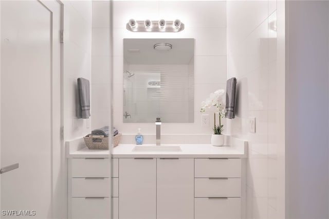 bathroom with vanity and a tile shower