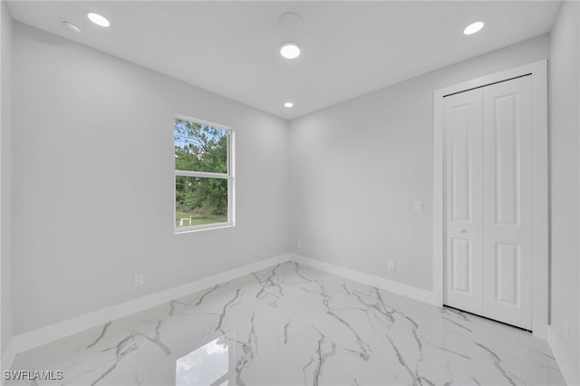 2932 18th St SW, Lehigh Acres, FL 33976 - spare room featuring marble look tile flooring, baseboards, recessed lighting, and a smoke detector