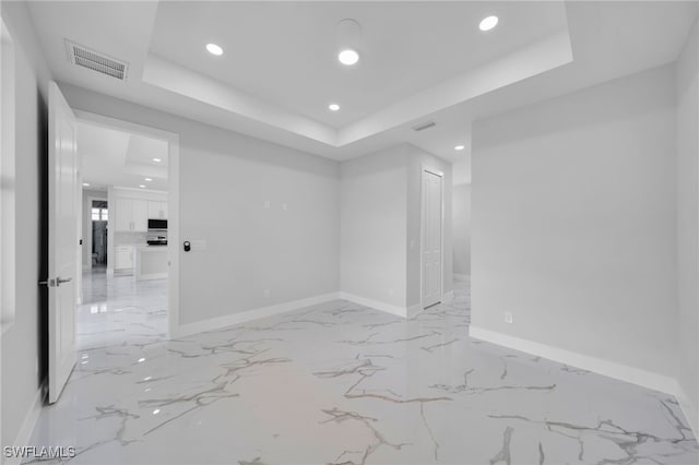 2932 18th St SW, Lehigh Acres, FL 33976 - unfurnished room featuring a raised ceiling, recessed lighting, light marble finish flooring, and baseboards