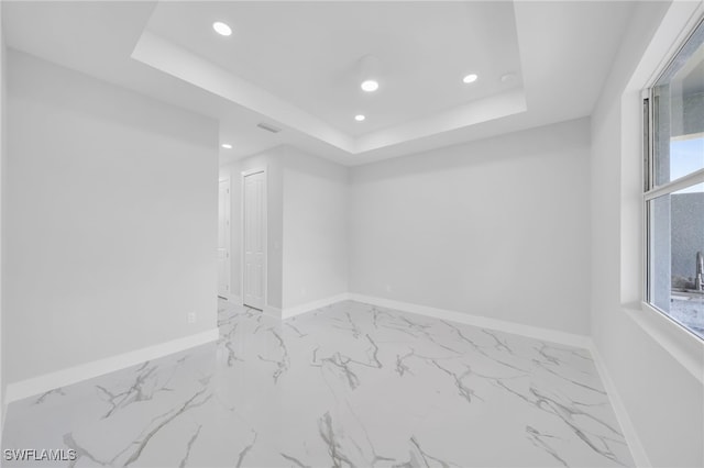 2932 18th St SW, Lehigh Acres, FL 33976 - spare room featuring recessed lighting, a raised ceiling, baseboards, and marble finish flooring