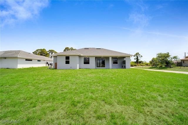 2932 18th St SW, Lehigh Acres, FL 33976 - back of house featuring a yard and stucco siding