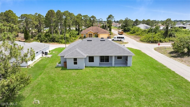 2932 18th St SW, Lehigh Acres, FL 33976 - rear view of property with a lawn, a shingled roof, a residential view, and stucco siding