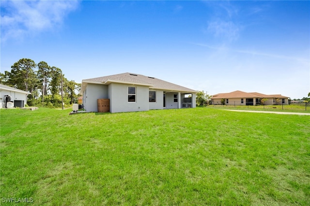 2932 18th St SW, Lehigh Acres, FL 33976 - rear view of property featuring a lawn and stucco siding