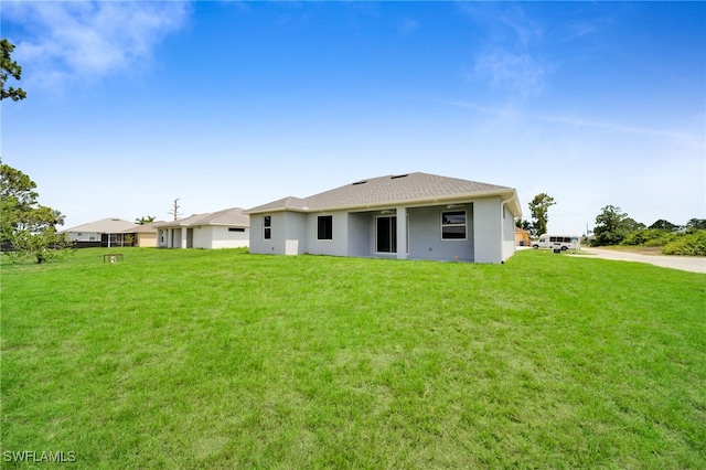 2932 18th St SW, Lehigh Acres, FL 33976 - back of house with a yard and stucco siding