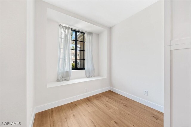 empty room with baseboards and light wood finished floors