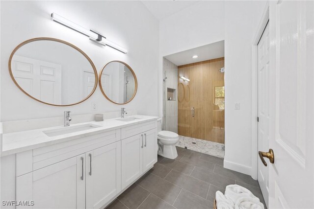 full bathroom featuring a stall shower, toilet, double vanity, and a sink