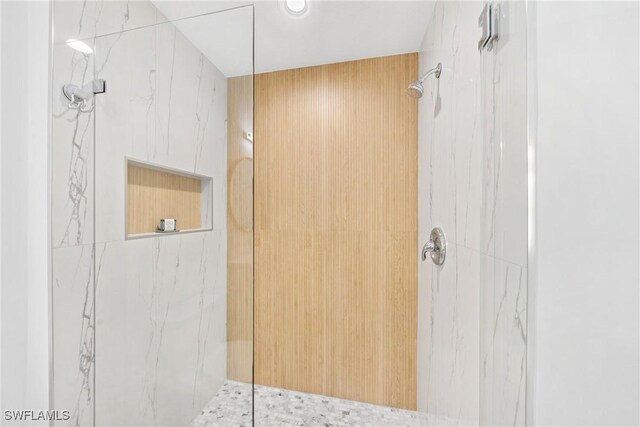 bathroom featuring a marble finish shower