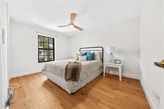 bedroom with baseboards, ceiling fan, and light wood finished floors