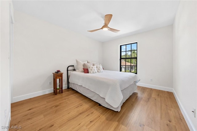 bedroom with light wood finished floors, ceiling fan, and baseboards