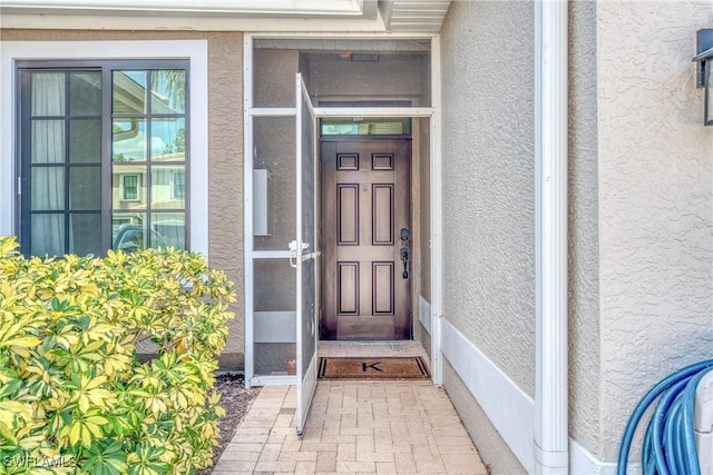 entrance to property with stucco siding
