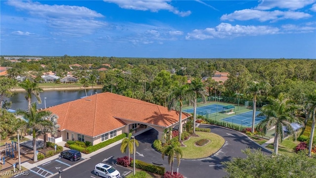 birds eye view of property with a water view and a wooded view