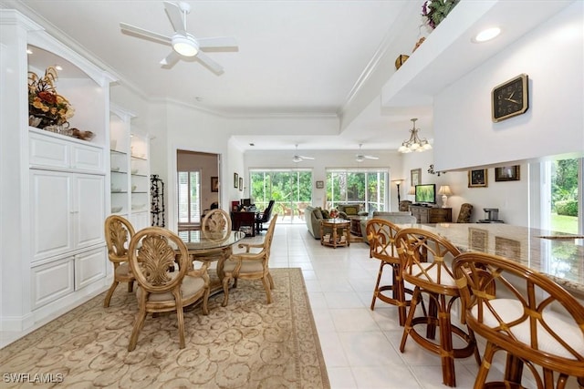 dining room with light tile patterned floors, a healthy amount of sunlight, a ceiling fan, and ornamental molding