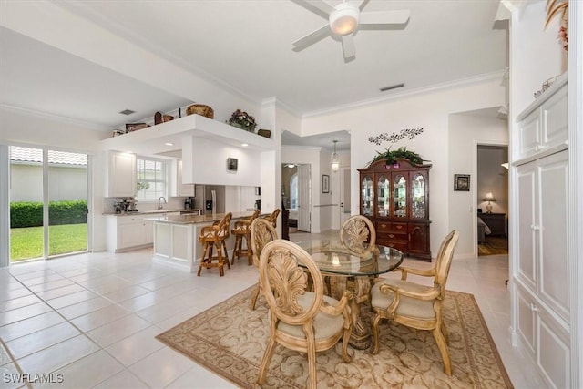 dining room featuring light tile patterned flooring, visible vents, ceiling fan, and ornamental molding