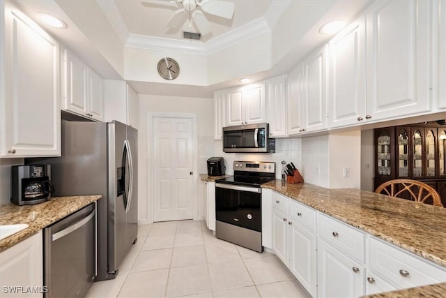 kitchen featuring white cabinetry, visible vents, stainless steel appliances, light tile patterned flooring, and ornamental molding