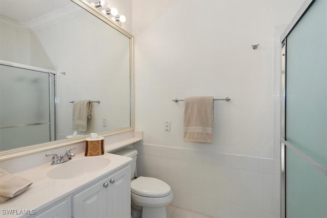 full bathroom featuring crown molding, a wainscoted wall, a shower with door, toilet, and vanity