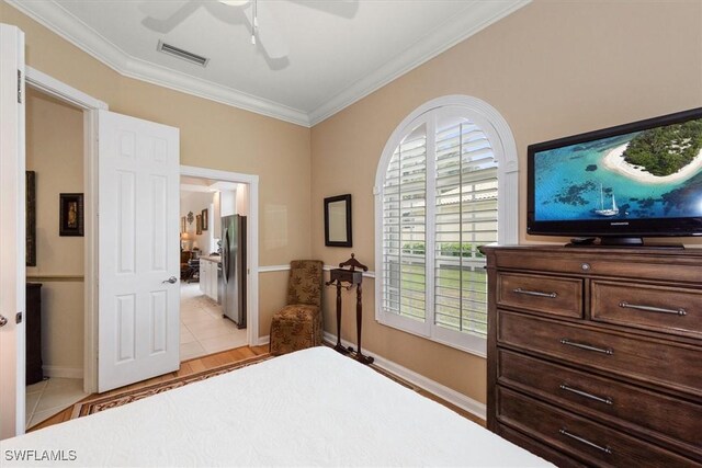 bedroom featuring freestanding refrigerator, ceiling fan, visible vents, light tile patterned flooring, and crown molding