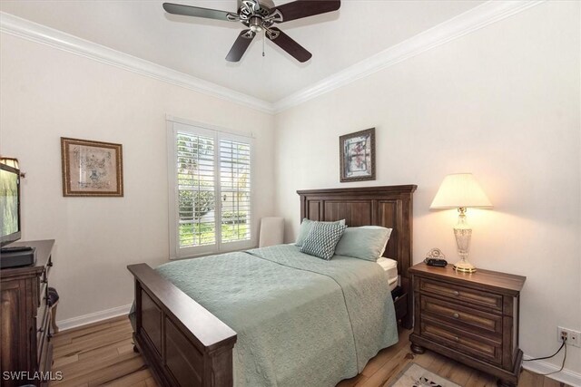 bedroom with baseboards, light wood-type flooring, a ceiling fan, and crown molding