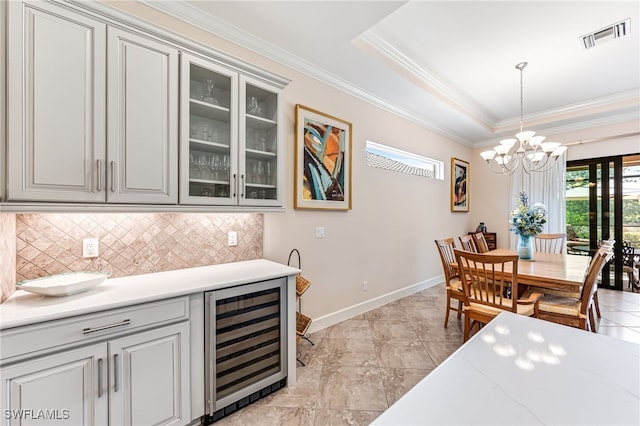 dining area featuring crown molding, beverage cooler, a chandelier, and a healthy amount of sunlight