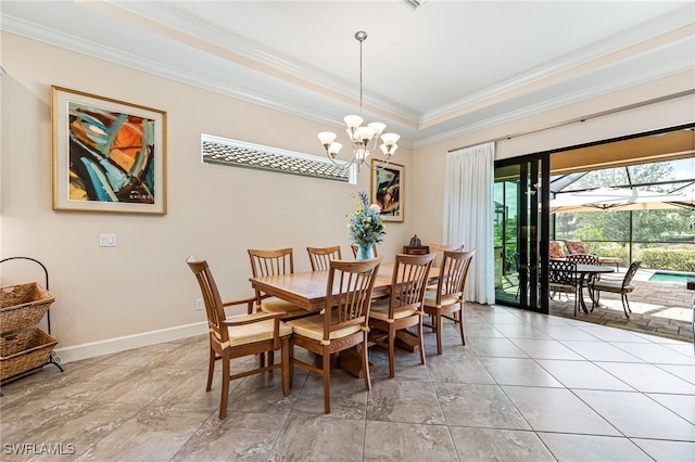 dining area with a chandelier, a raised ceiling, crown molding, and baseboards