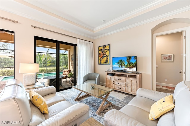 living area featuring baseboards and crown molding