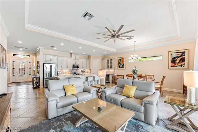 living room with crown molding, ceiling fan with notable chandelier, visible vents, and a raised ceiling