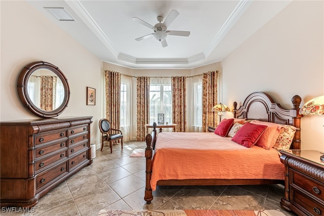 tiled bedroom with crown molding, visible vents, ceiling fan, and a tray ceiling