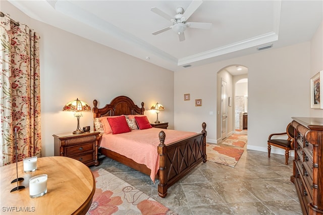 bedroom featuring a tray ceiling, stone finish floor, visible vents, arched walkways, and crown molding