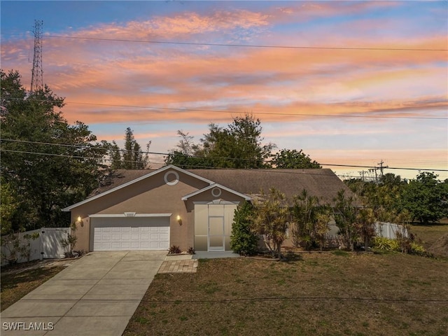 1551 Evalena Ln, North Fort Myers, FL 33917 - view of front of home featuring fence, a yard, stucco siding, an attached garage, and concrete driveway