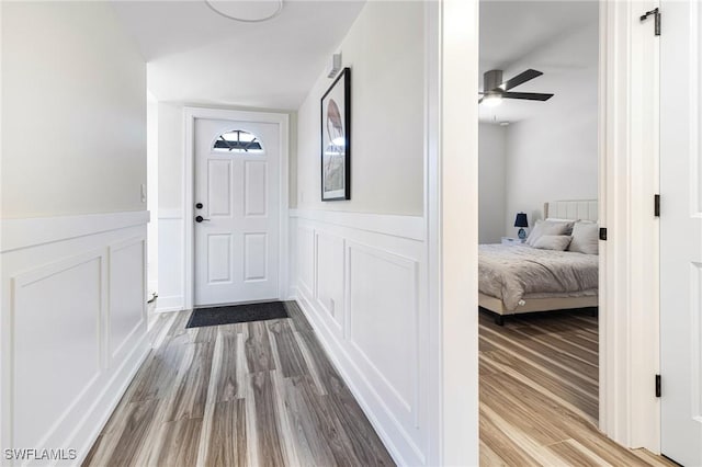 12181 Kelly Sands Way Unit 1538, Fort Myers, FL 33908 - hallway featuring wainscoting, a decorative wall, and wood finished floors