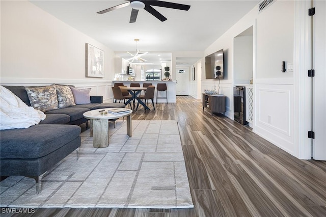 12181 Kelly Sands Way Unit 1538, Fort Myers, FL 33908 - living area featuring wood finished floors, ceiling fan with notable chandelier, visible vents, a decorative wall, and wainscoting