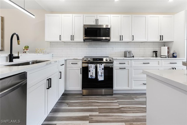 12181 Kelly Sands Way Unit 1538, Fort Myers, FL 33908 - kitchen with light stone countertops, tasteful backsplash, a sink, white cabinets, and appliances with stainless steel finishes