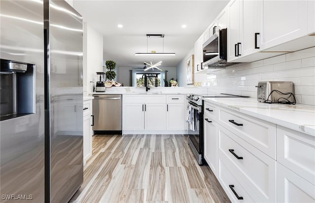 12181 Kelly Sands Way Unit 1538, Fort Myers, FL 33908 - kitchen featuring a sink, stainless steel appliances, white cabinetry, tasteful backsplash, and light stone counters
