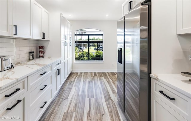 12181 Kelly Sands Way Unit 1538, Fort Myers, FL 33908 - kitchen with light wood-style flooring, recessed lighting, white cabinetry, stainless steel fridge, and decorative backsplash