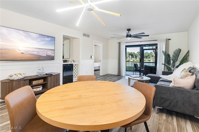 12181 Kelly Sands Way Unit 1538, Fort Myers, FL 33908 - dining space featuring beverage cooler, visible vents, wood finished floors, and wainscoting