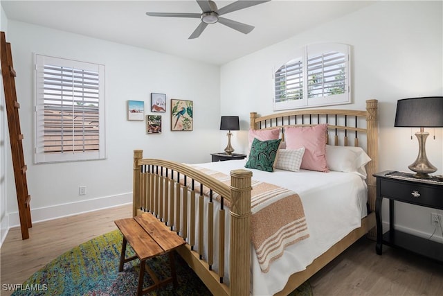 bedroom with multiple windows, ceiling fan, wood finished floors, and baseboards
