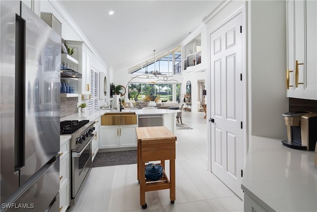 kitchen featuring lofted ceiling, a sink, stainless steel appliances, and light countertops