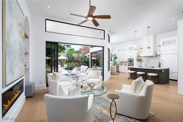 204 Monterey Dr, Naples, FL 34119 - living room featuring light wood-style flooring, recessed lighting, ceiling fan, a glass covered fireplace, and baseboards
