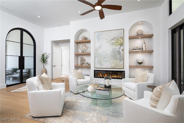 204 Monterey Dr, Naples, FL 34119 - living room with built in shelves, a glass covered fireplace, a ceiling fan, wood finished floors, and recessed lighting