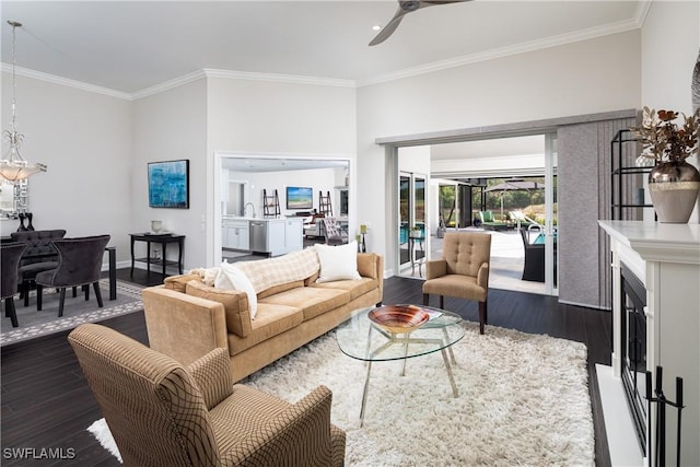 living room featuring crown molding, a ceiling fan, dark wood-style flooring, and baseboards