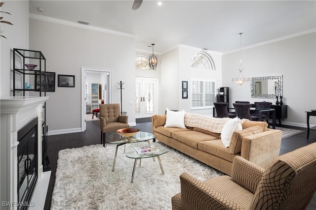 living room featuring dark wood-style flooring, ornamental molding, and baseboards