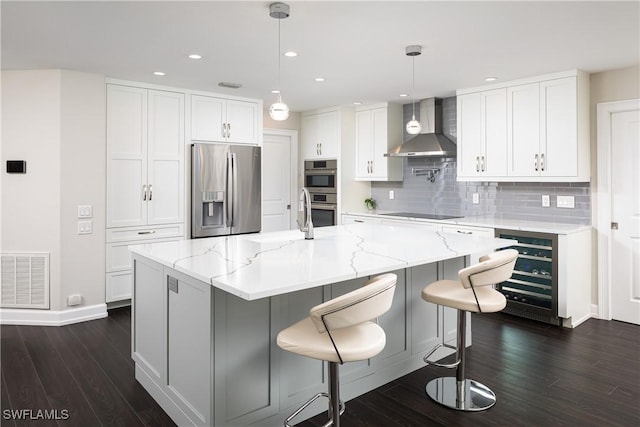 kitchen featuring wall chimney range hood, appliances with stainless steel finishes, beverage cooler, visible vents, and dark wood-style flooring