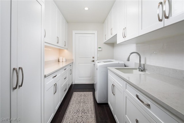 laundry room featuring dark wood-style floors, recessed lighting, a sink, cabinet space, and washing machine and dryer