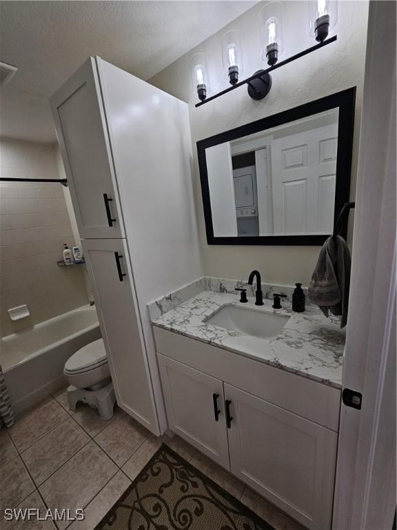 19942 Lake Vista Cir N Unit 2, Lehigh Acres, FL 33936 - bathroom featuring washtub / shower combination, tile patterned floors, vanity, and toilet