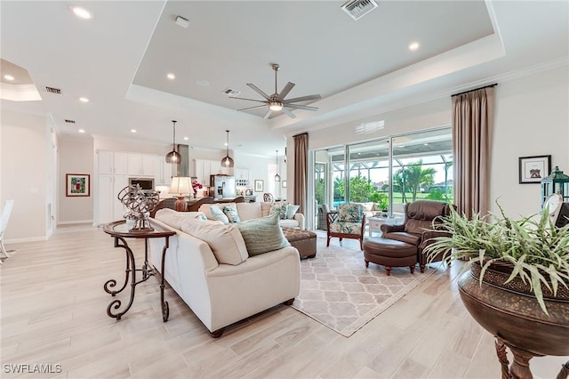 15951 Talon Ter, Punta Gorda, FL 33982 - living room featuring a raised ceiling, a ceiling fan, light wood-type flooring, and visible vents